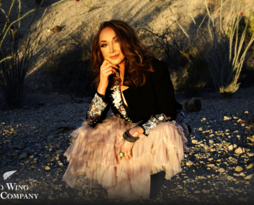 Pam Tillis - Oct 13 woman sitting on a rocky beach